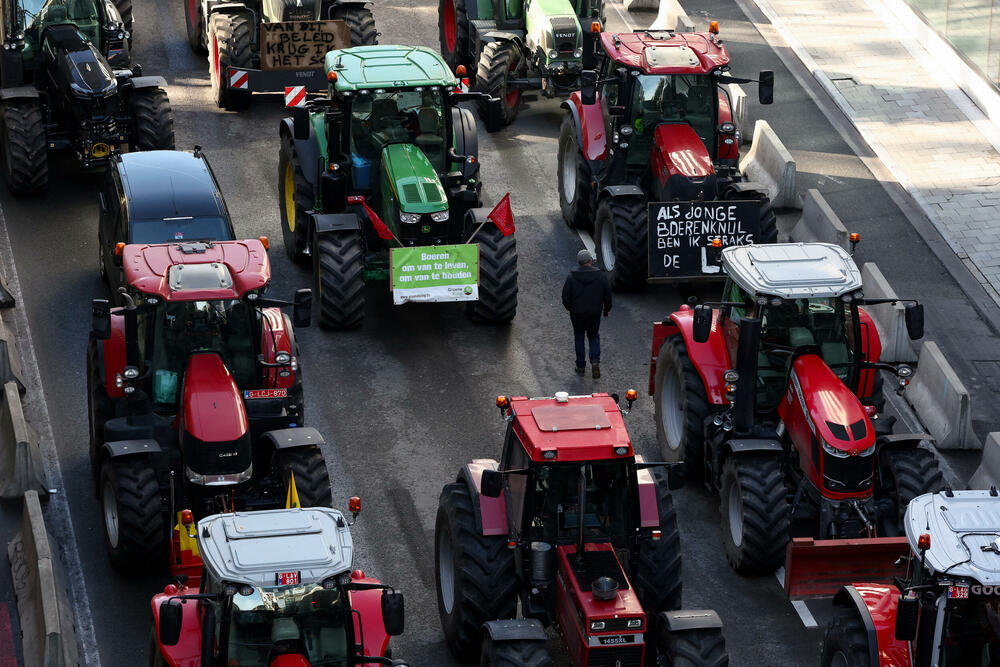 Čovjek hoda među traktorima dok belgijski farmeri blokiraju put u blizini Evropskog parlamenta u Briselu, Belgija