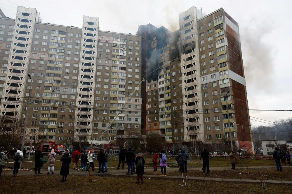 Lokalno stanovništvo posmatra vatrogasce kako rade na mjestu zgrade oštećene tokom ruskog raketnog udara, u Kijevu (7. februar), Foto: Reuters