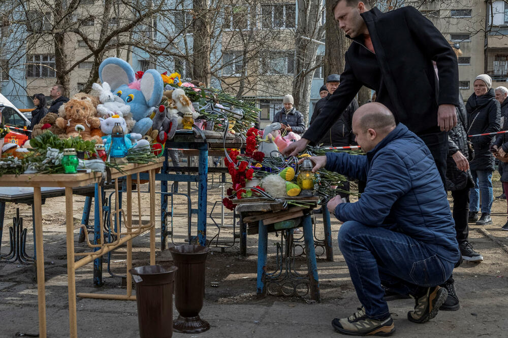 Ljudi pale svijeće i polažu cvijeće na improvizovani spomenik žrtvama napada dronovima od prethodnog dana koji je teško oštetio stambenu zgradu, usred ruskog napada na Ukrajinu, u Odesi, Foto: Reuters