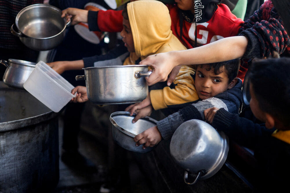 Palestinska djeca u Rafi čekaju hranu iz humanitarne kuhinje, Foto: Rojters