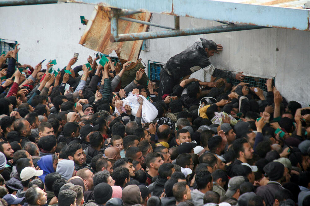 Palestinci čekaju da dobiju hranu ispred skladišta UNRWA u gradu Gaza, Foto: Rojters