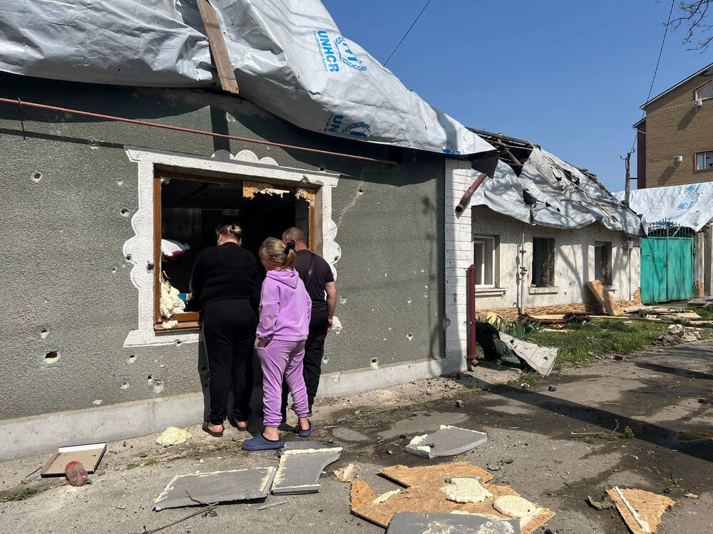 People look through a broken window at a house damaged by a Russian missile strike in Nikolayev, April 11, 2024.