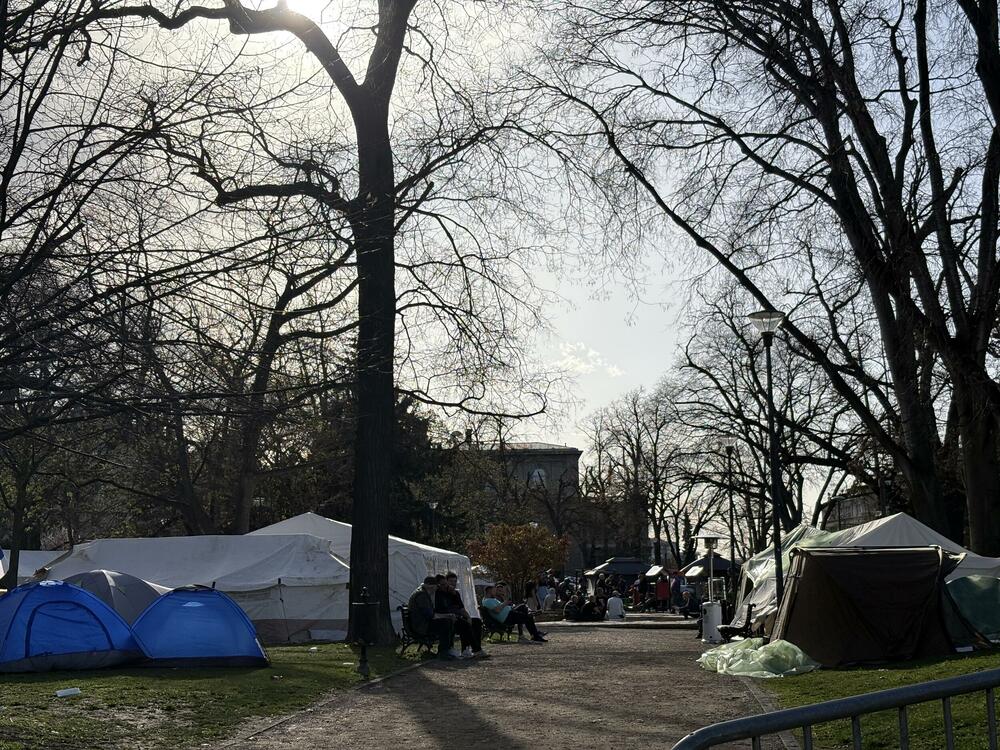 <p>Privremeni stanovnici Pionirskog parka nijesu bili raspoloženi za razgovor a ni za slikanje i snimanje. Svoje vrijeme su provodili sjedeći na klupama, u svojim šatorima i između njih. Žandarmerija im je kasnije danas pojačala obezbjeđenje</p>