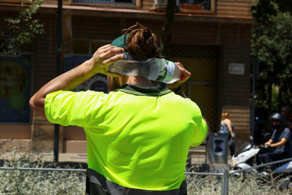 Baštovan pokušava da se rashladi tokom vrelog talasa u Barseloni, Foto: Rojters