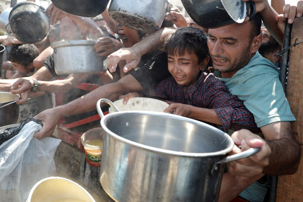Palestinci čekaju da dobiju hranu iz dobrotvorne kuhinje u gradu Gazi, Foto: Reuters