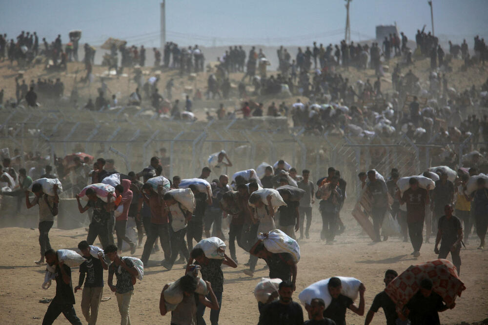 Palestinci nose zalihe koje su dobili od Humanitarne fondacije za Gazu (GHF), Foto: Rojters