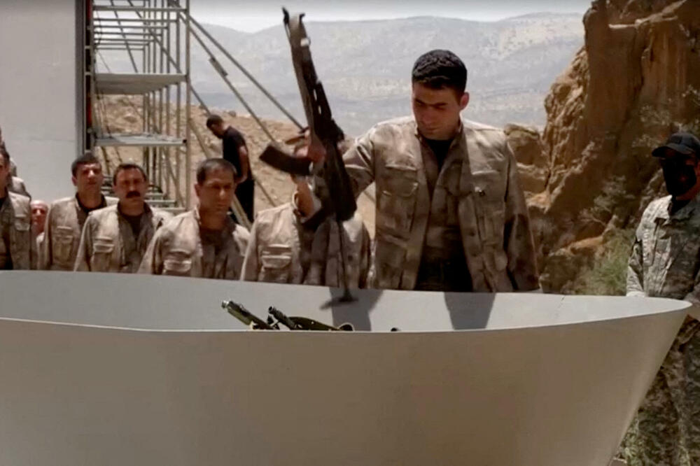 Naoružani borac PKK stavlja oružje na spaljivanje tokom ceremonije razoružavanja, Foto: Reuters