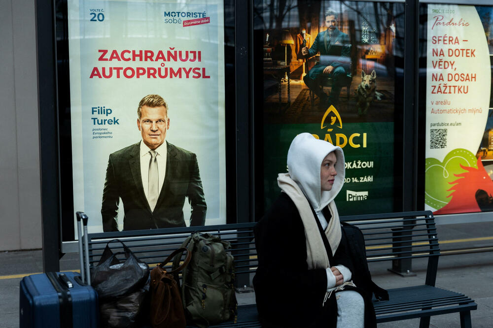 Žena sjedi pored izbornog plakata evroparlamentarca Filipa Tureka, Foto: REUTERS