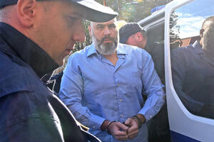 Na snimku se vidi kako Mandić podiže predmet nalik na pištolj