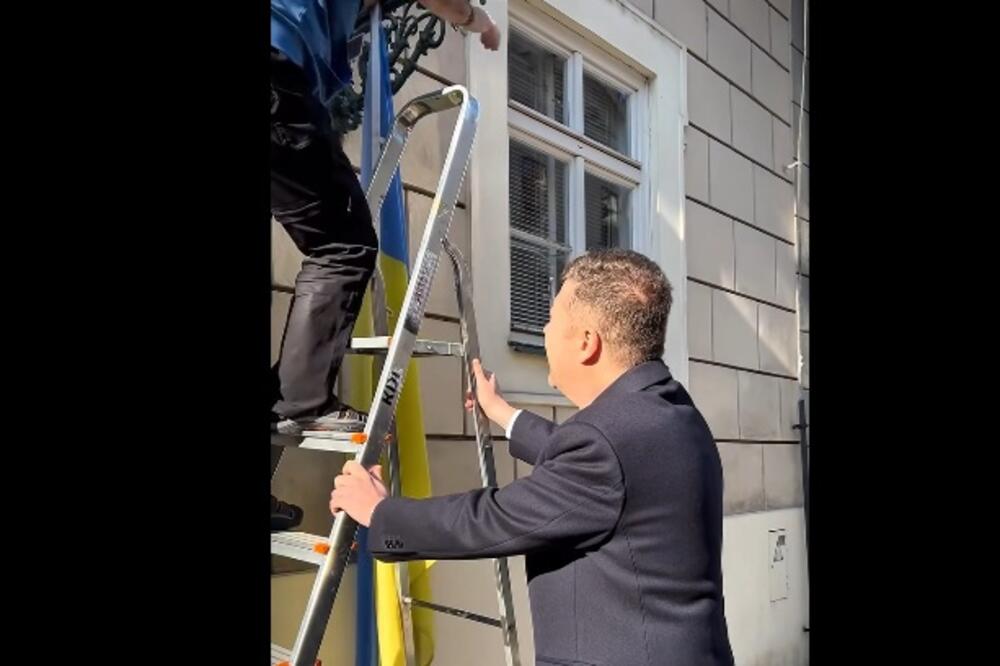 Okamura pridržava merdevine činovniku koji skida zastavu Ukrajine, Foto: Fejsbuk