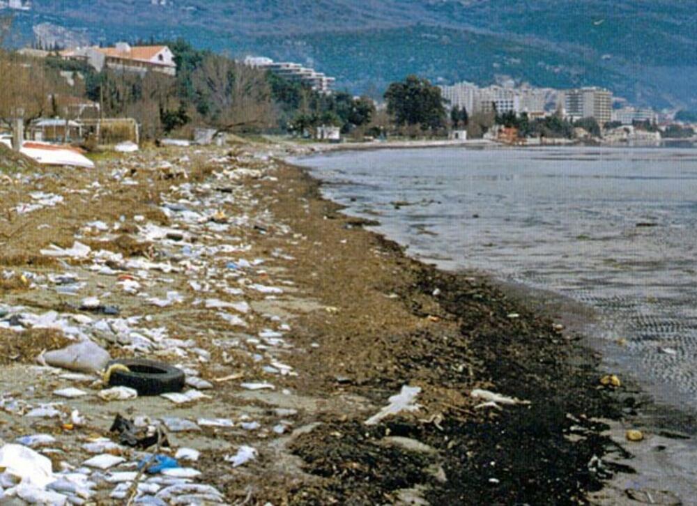 „Blatna plaža“ na ušću rijeke Sutorine (ispod  Titove vile) sa čvrstim otpadom koji potiče iz naselja u slivu rijeke (Iz  studije Lj. Radojičića: “Katastar rasutih zagađivača Topljanskog zaliva“)