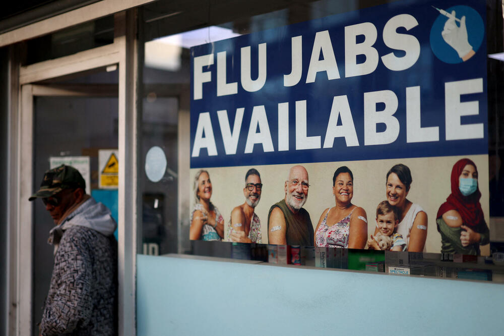 Reklama za vakcine protiv gripa u izlogu apoteke u Londonu, Foto: Rojters
