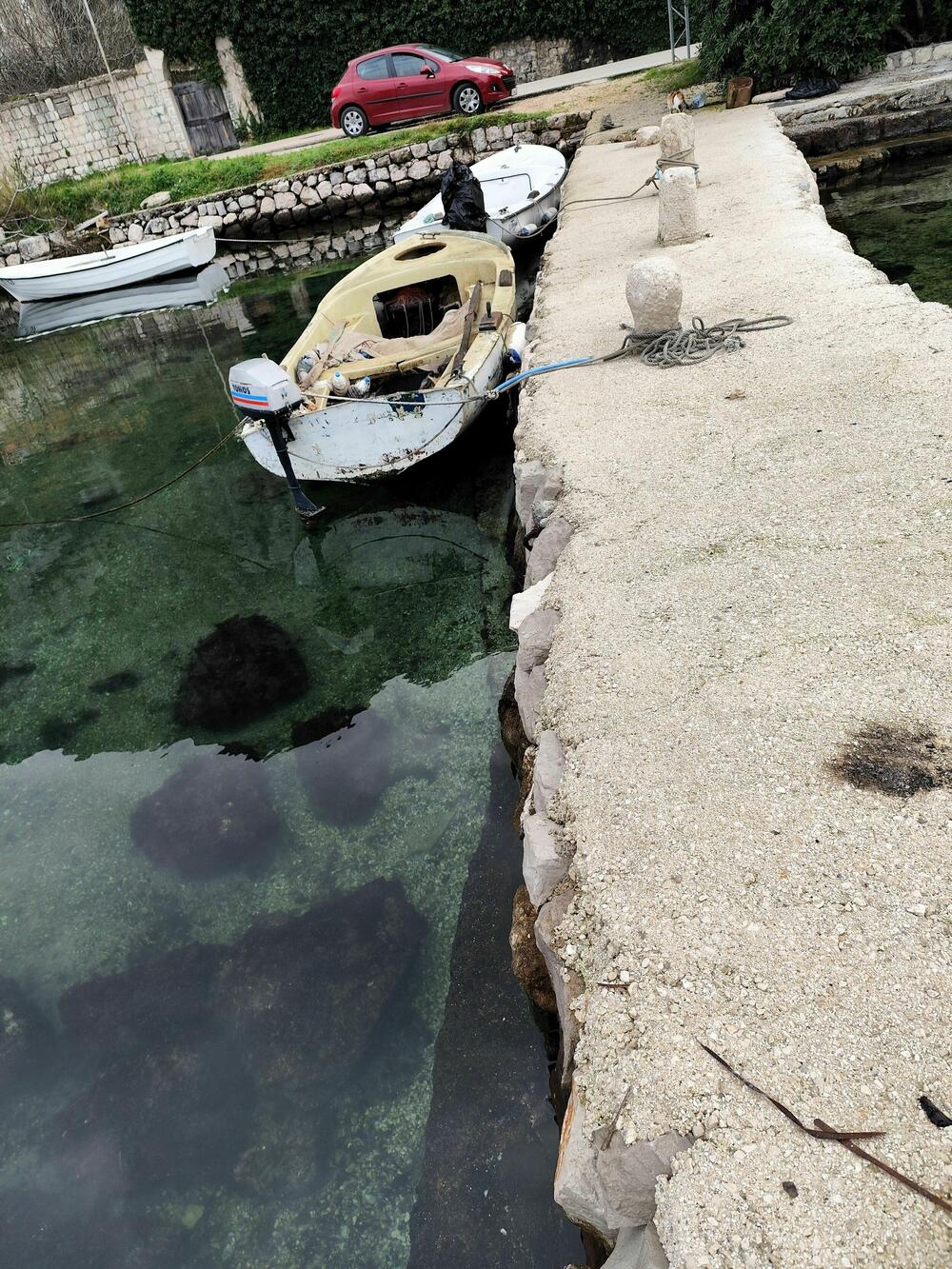 Betonska cokla uz mulo i ostavljeno kamenje u moru