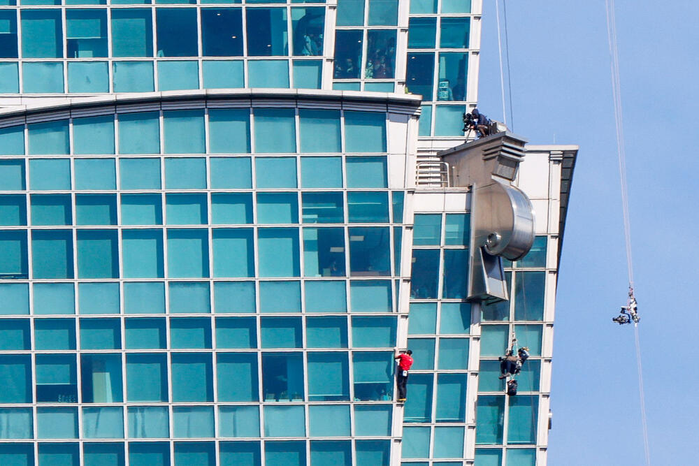 <p>Ljudi okupljeni na ulici ispod nebodera pozdravili su usklicima trenutak kada je Honold stigao na vrh na visini od 508 metara poslije 90 minuta penjanja</p>