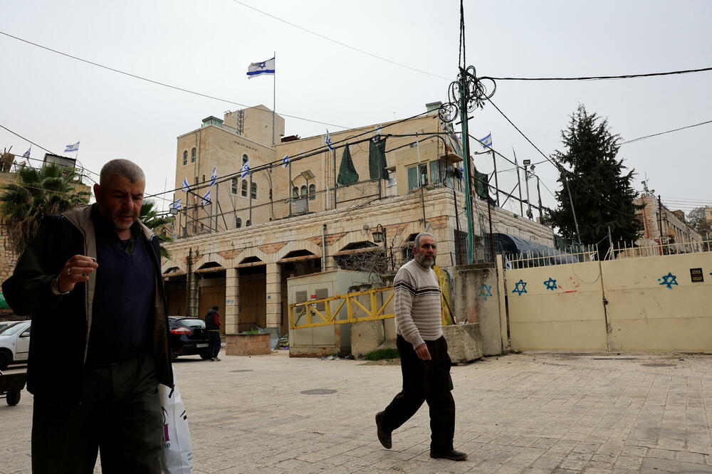 Palestinci prolaze ispred izraelskog naselja u starom gradu Hebronu na Zapadnoj obali koja je pod izraelskom okupacijom, Foto: Reuters