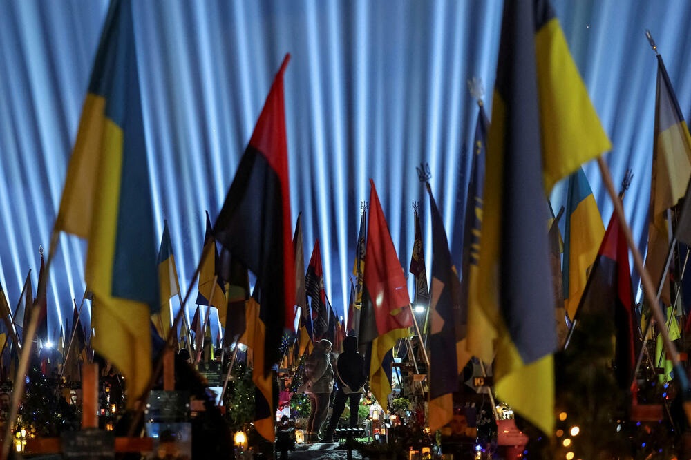 Ljudi obilaze grobove svojih rođaka, koji su poginuli tokom ruskog napada na Ukrajinu, dok velika svjetlosna instalacija "Svjetla sjećanja" osvjetljava Ličakivsko groblje u Lavovu, na zapadu Ukrajine, Foto: Reuters