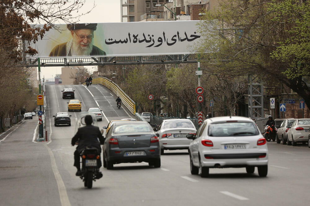 Detalj iz Teherana, glavnog grada Irana: Ljudi voze pored transparenta s likom pokojnog iranskog vrhovnog lidera, ajatolaha Alija Hamneija, Foto: Reuters