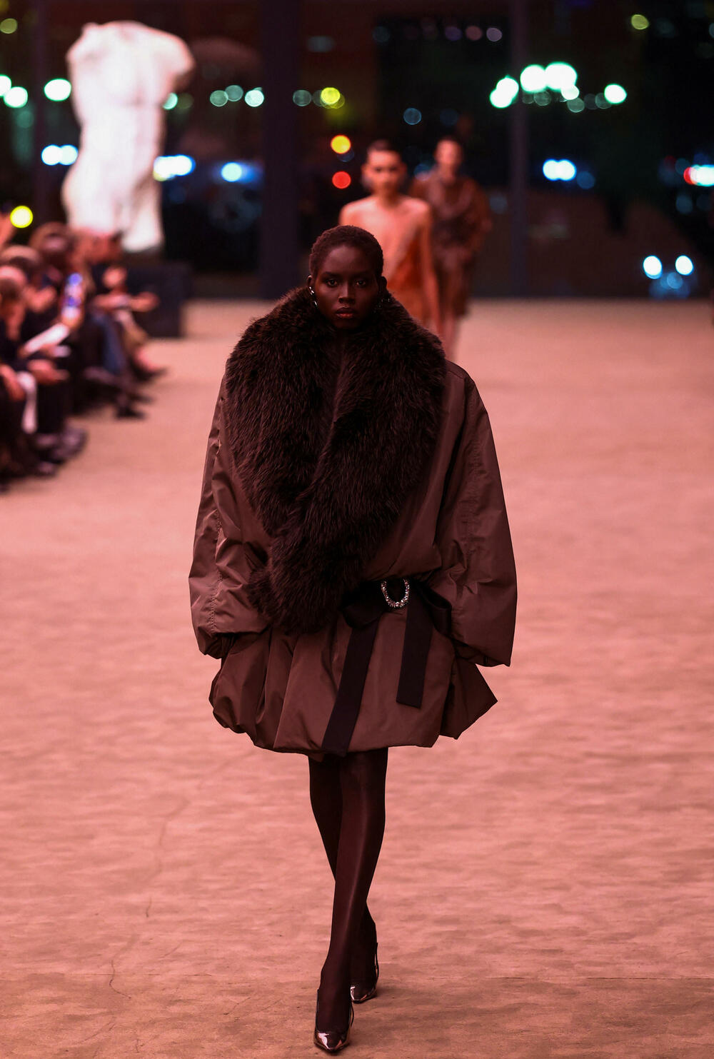 <p>Revija je otvorena nizom moćnih crnih odijela sa velikim reverima i naglašenim ramenima - što priziva ženski smoking koji je francuski dizajner Ivo Sen Loran kreirao 1966. godine, kršeći tadašnju tradiciju</p>