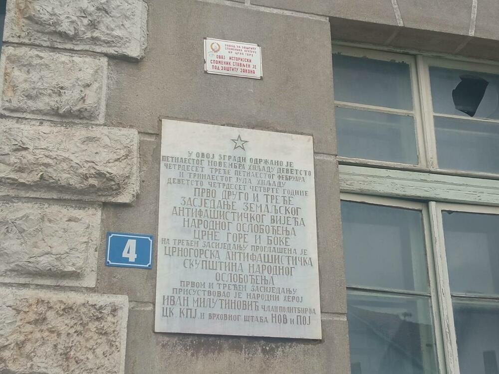 Spomen-ploča i polomljena stakla