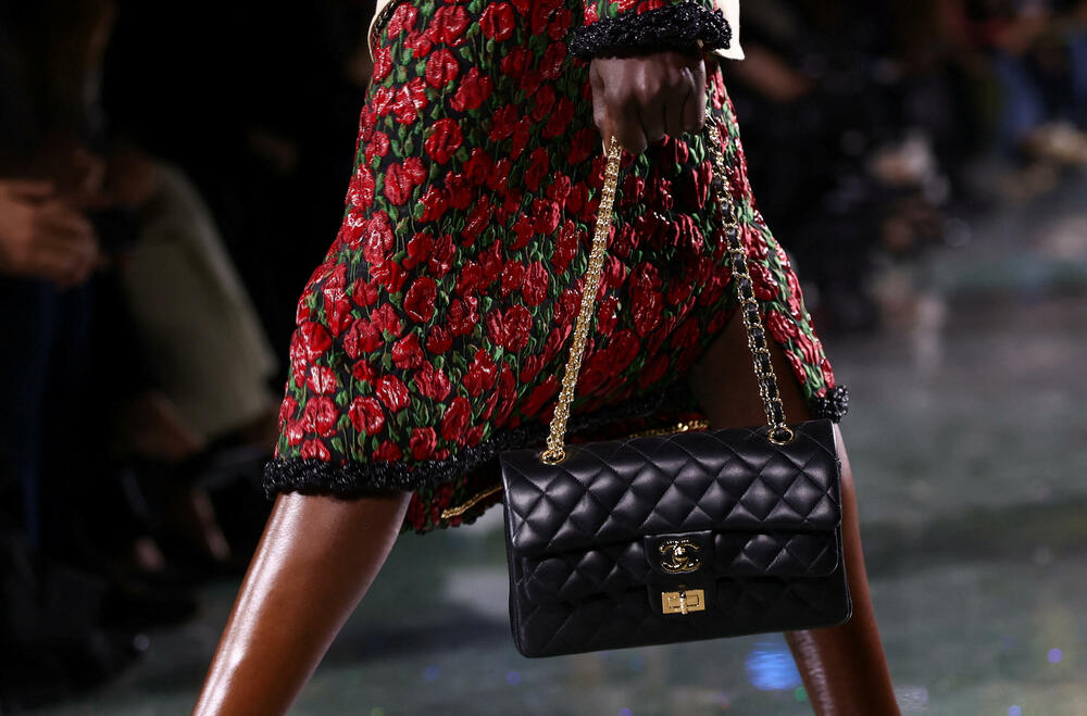 <p>Kostimi su bili kombinovani sa neuvučenim košuljama u kontrastnim dezenima i bojama, te upareni sa klasičnim Šanelovim dvobojnim salonkama u upadljivim kontrastima poput crvene i prelivajuće lila nijanse</p>