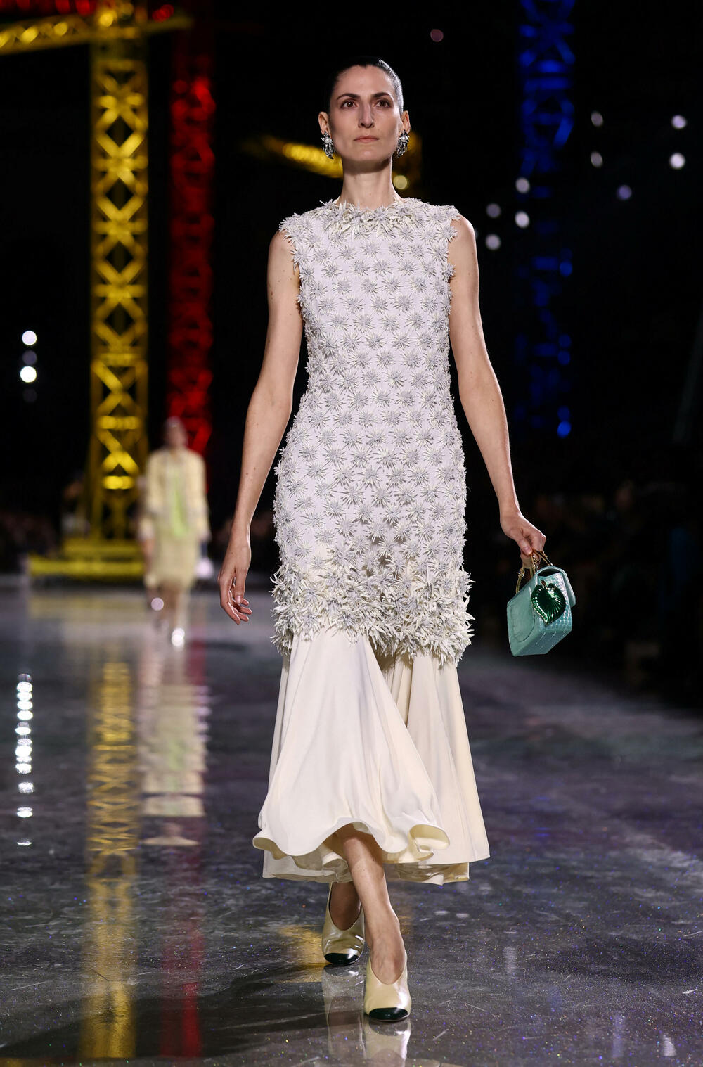 <p>Kostimi su bili kombinovani sa neuvučenim košuljama u kontrastnim dezenima i bojama, te upareni sa klasičnim Šanelovim dvobojnim salonkama u upadljivim kontrastima poput crvene i prelivajuće lila nijanse</p>