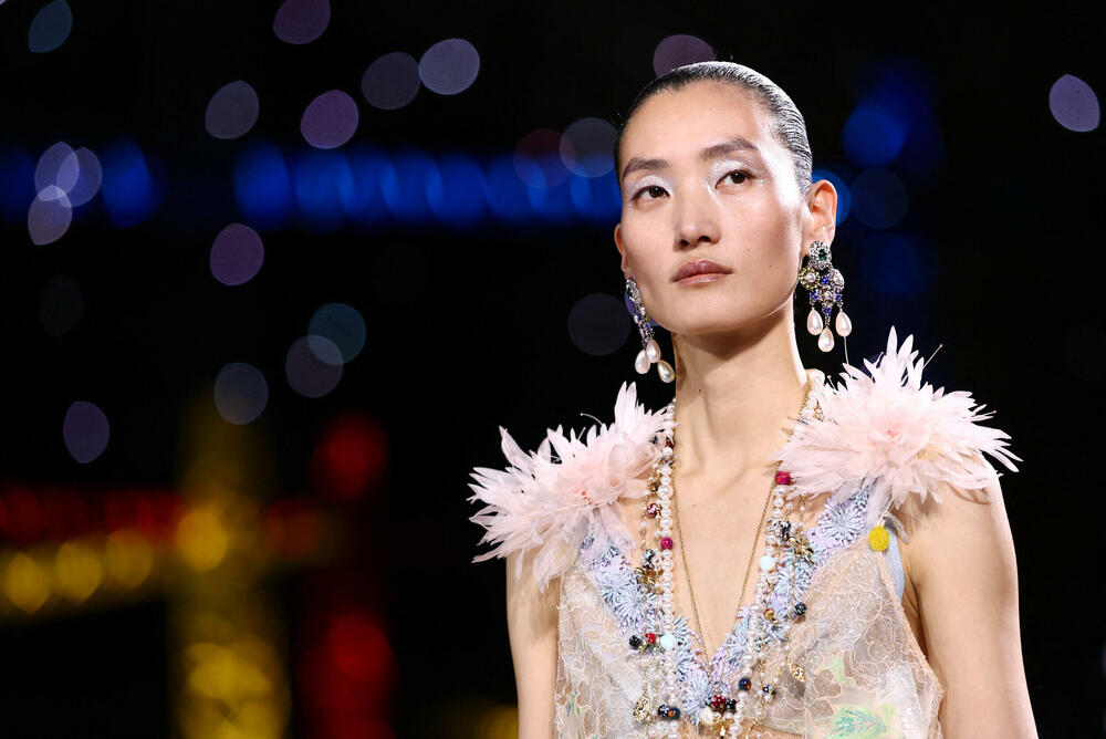 <p>Kostimi su bili kombinovani sa neuvučenim košuljama u kontrastnim dezenima i bojama, te upareni sa klasičnim Šanelovim dvobojnim salonkama u upadljivim kontrastima poput crvene i prelivajuće lila nijanse</p>