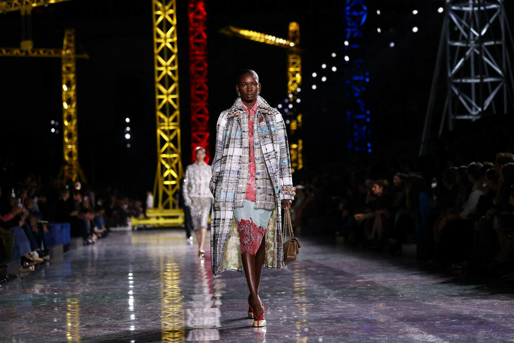 <p>Kostimi su bili kombinovani sa neuvučenim košuljama u kontrastnim dezenima i bojama, te upareni sa klasičnim Šanelovim dvobojnim salonkama u upadljivim kontrastima poput crvene i prelivajuće lila nijanse</p>