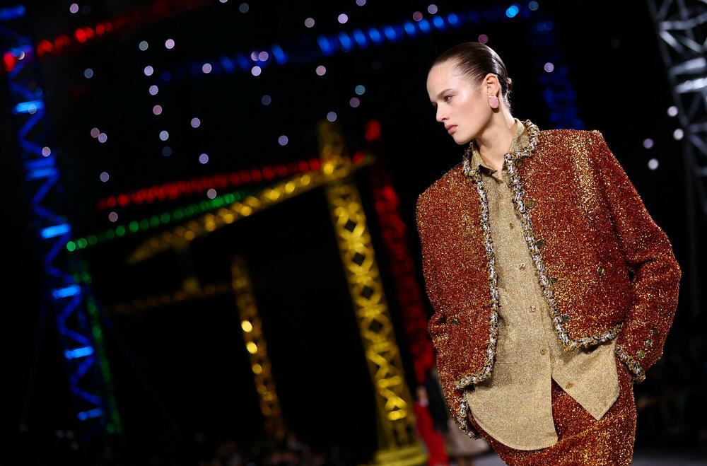 <p>Kostimi su bili kombinovani sa neuvučenim košuljama u kontrastnim dezenima i bojama, te upareni sa klasičnim Šanelovim dvobojnim salonkama u upadljivim kontrastima poput crvene i prelivajuće lila nijanse</p>