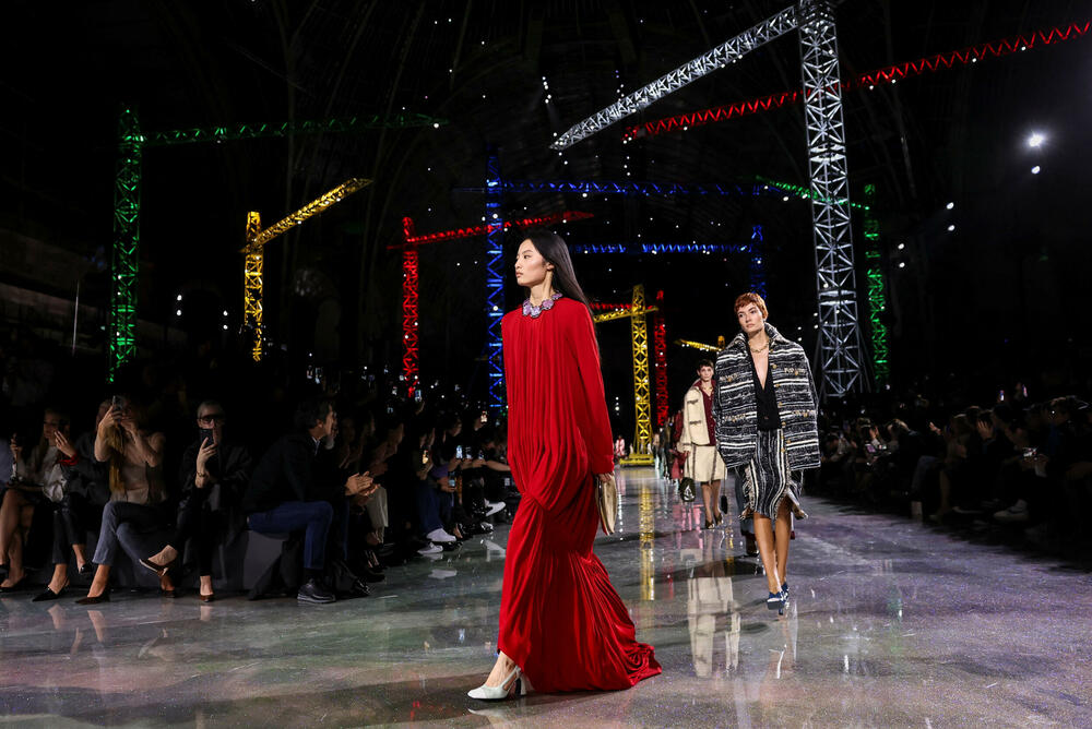 <p>Kostimi su bili kombinovani sa neuvučenim košuljama u kontrastnim dezenima i bojama, te upareni sa klasičnim Šanelovim dvobojnim salonkama u upadljivim kontrastima poput crvene i prelivajuće lila nijanse</p>