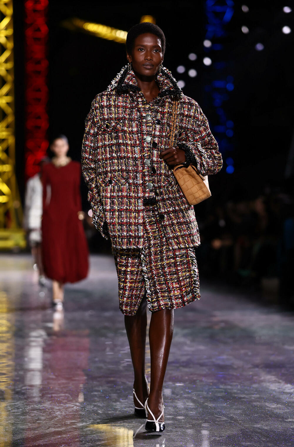 <p>Kostimi su bili kombinovani sa neuvučenim košuljama u kontrastnim dezenima i bojama, te upareni sa klasičnim Šanelovim dvobojnim salonkama u upadljivim kontrastima poput crvene i prelivajuće lila nijanse</p>