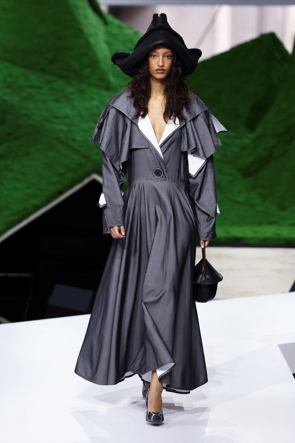 <p>Manekenke su koračale pistom pred scenografijom od nazubljenih zelenih oblika koji su podsjećali na planine, noseći grane okićene torbama ili podižući iznad glave velike pletene korpe</p>