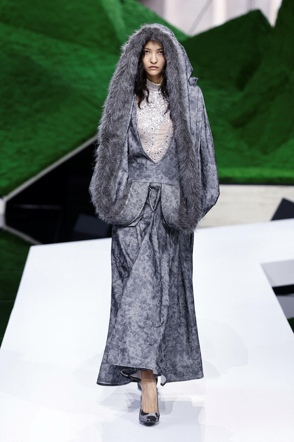 <p>Manekenke su koračale pistom pred scenografijom od nazubljenih zelenih oblika koji su podsjećali na planine, noseći grane okićene torbama ili podižući iznad glave velike pletene korpe</p>