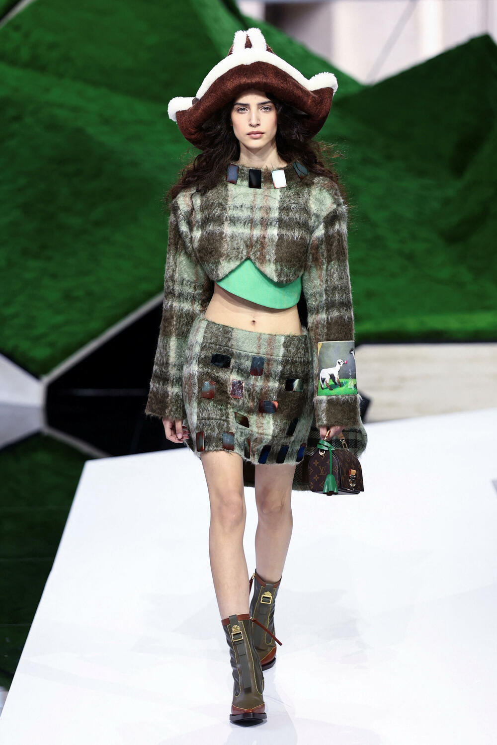 <p>Manekenke su koračale pistom pred scenografijom od nazubljenih zelenih oblika koji su podsjećali na planine, noseći grane okićene torbama ili podižući iznad glave velike pletene korpe</p>