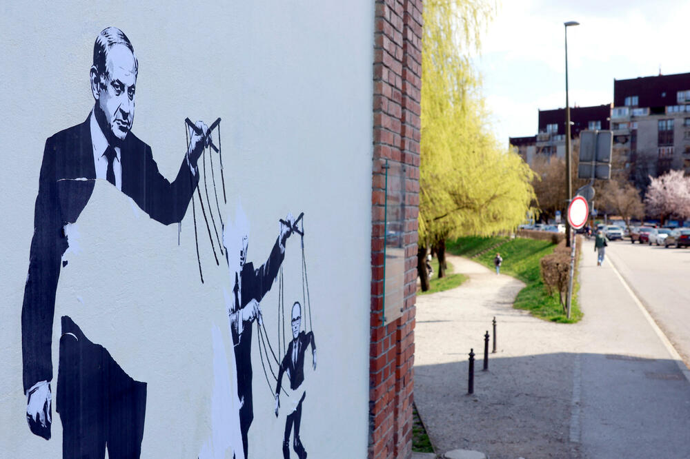 Umjetnički rad na zidu u Ljubljani prikazuje izraelskog premijera Benjamina Netanjahua kako povlači konce povezane sa bivšim premijerom Slovenije Janezom Janšom, koji povlači konce na kojima je povezan Anže Logar, Foto: Reuters