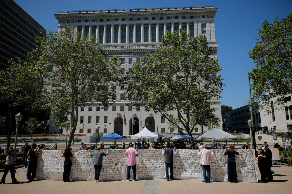 Roditelji koji tvrde da su izgubili svoju djecu zbog društvenih mreža drže transparent sa imenima djece ispred suda,