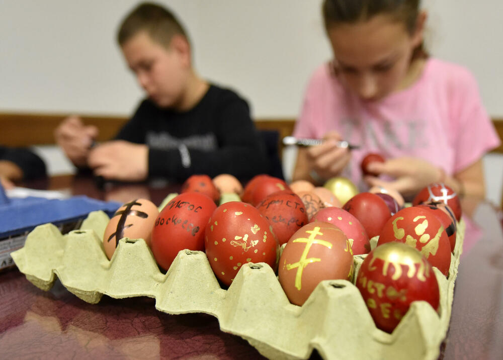 <p>Učenici vjeronauke pri hramu Hristovog Vaskrsenja u Podgorici danas, na Veliki petak, ukrašavaju varskšnja jaja pod budnim okom svoje vjeroučiteljice.</p>
