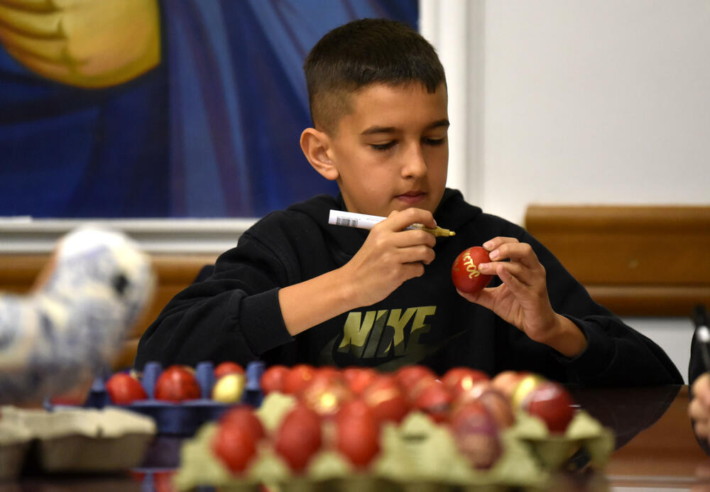 <p>Učenici vjeronauke pri hramu Hristovog Vaskrsenja u Podgorici danas, na Veliki petak, ukrašavaju varskšnja jaja pod budnim okom svoje vjeroučiteljice.</p>