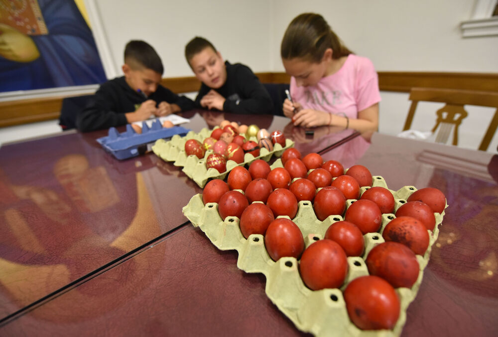 <p>Učenici vjeronauke pri hramu Hristovog Vaskrsenja u Podgorici danas, na Veliki petak, ukrašavaju varskšnja jaja pod budnim okom svoje vjeroučiteljice.</p>