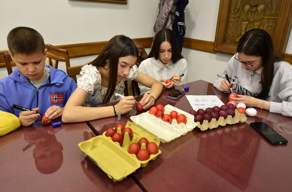 <p>Učenici vjeronauke pri hramu Hristovog Vaskrsenja u Podgorici danas, na Veliki petak, ukrašavaju varskšnja jaja pod budnim okom svoje vjeroučiteljice.</p>