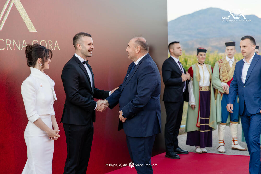 <p>Sinoć je premijer Milojko Spajić u vinogradu &bdquo;13. jul Plantaže&ldquo; organizovao svečani prijem povodom 20 godina od odnove nezavisnosti. Prijemu su, između ostalih, prisustvovali predsjednik države Jakov Milatović, članovi Vlade, predsjednik Skupštine Andrija Mandić, evropska komesarka Marta Kos, Izvjestilac za Crnu Goru u Evropskom parlamentu Marjan Šarec.bivši predsjednici države Milo Đukanović i Filip Vujanović, nekadašnji premijer Duško Marković, predstavnici parlamentarnih političkih partija, ambasadori, glavni specijalni tužilac i vrhovni državni tužilac Vladimir Novović i Milorad Marković, predsjednica Vrhovnog suda Valentina Pavličić, prestolonasljednik princ Nikola Petrović Njegoš. Događaju su, takođe, prisustvovali pojedini predsjednici opština, direktor Uprave policije Lazar Šćepanović, načelnik generalštaba Miodrag Vuksanović, predstavnici medija, Srpske pravoslavne crkve, Crnogorske pravoslavne crkve, Islamske zajednice, Katoličke crkve i Jevrejske zajednice, direktori preduzeća u državnom vlasništvu, privrednici.</p>  <p>Od gostiju iz regiona, prisutan je bio član predstedništva BiH Željko Komšić.</p>  <p>Na prijemu nije bio nekadašnji premijer Dritan Abazović (Građanski pokret URA), ali ni predstavnici njegove stranke, Demokratske narodne partije Milana Kneževića, Socijalističke narodne partije i Ujedinjene Crne Gore.</p>