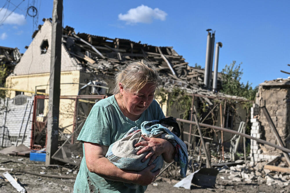 Žena nosi mačku u blizini kuće oštećene u ruskom vazdušnom napadu, tokom ruskog napada na Ukrajinu, u Zaporožju, Ukrajina., Foto: Reuters