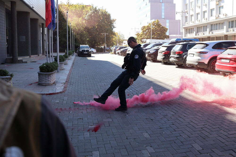 Kosovski policajac sklanja baklju u blizini zgrade parlamenta tokom vanredne sjednice na kojoj se glasa o ograničavanju ovlašćenja suda za ratne zločine sa sjedištem u Hagu: Detalj iz Prištine, glavnog grada Kosova, 5. oktobra 2026., Foto: Reuters