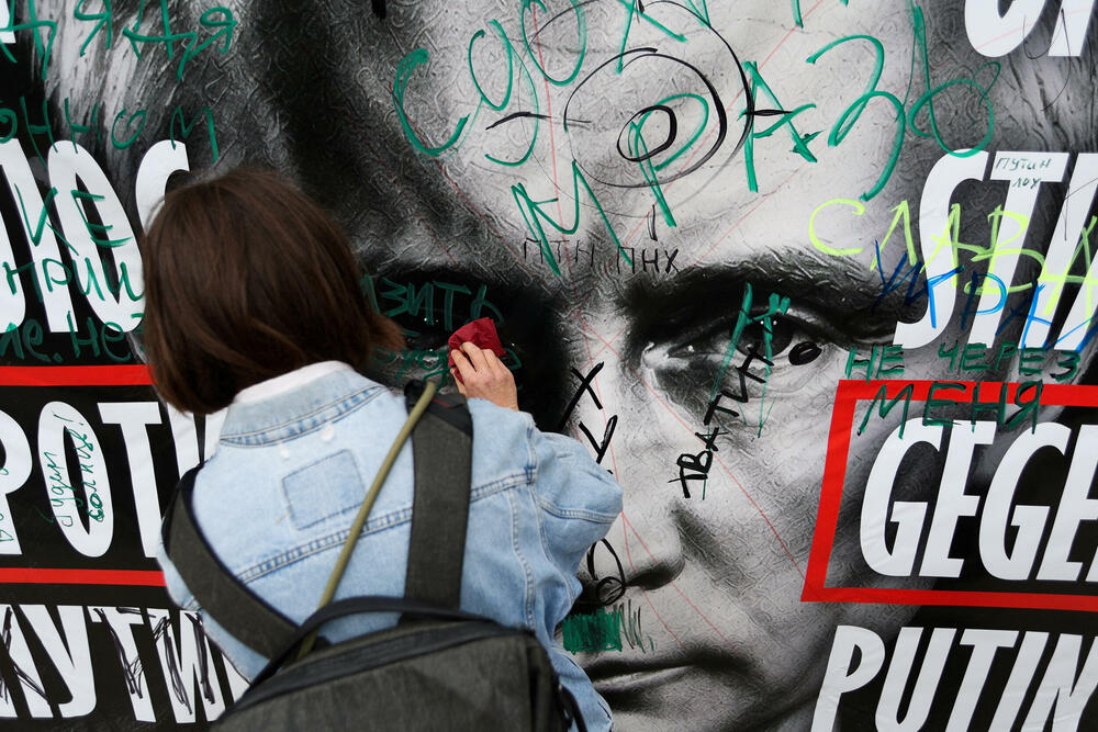 Brisanje transparenta s Putinovim likom tokom protesta ispred ruske ambasade u Berlinu