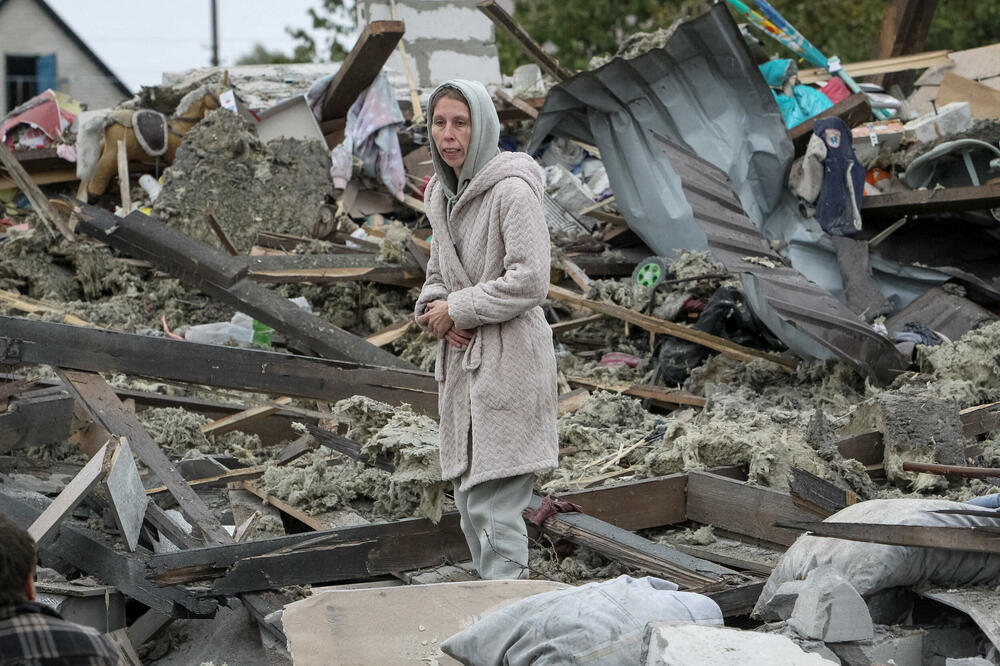 Žena pored kuće uništene u ruskom napadu u predgrađu Dnjepra, Foto: Rojters