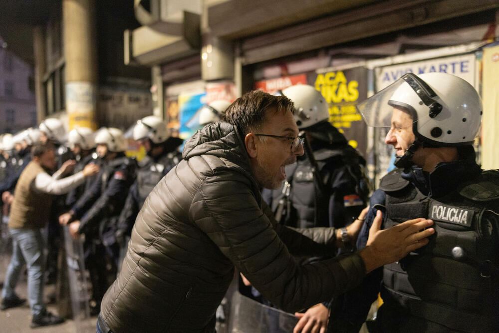 Pristalica Studentske liste u razgovoru s policajcem tokom slavlja u Beogradu