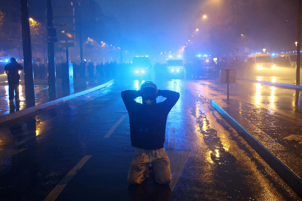 Maskirani demonstrant kleči ispred francuskih policajaca 24. oktobra tokom sukoba na protestu koji su organizovali sindikati u Parizu, u okviru protesta širom zemlje na poziv pokreta "Žuti prsluci", kojima su se pridružili  srednjoškolci i studenti, Foto: Reuters