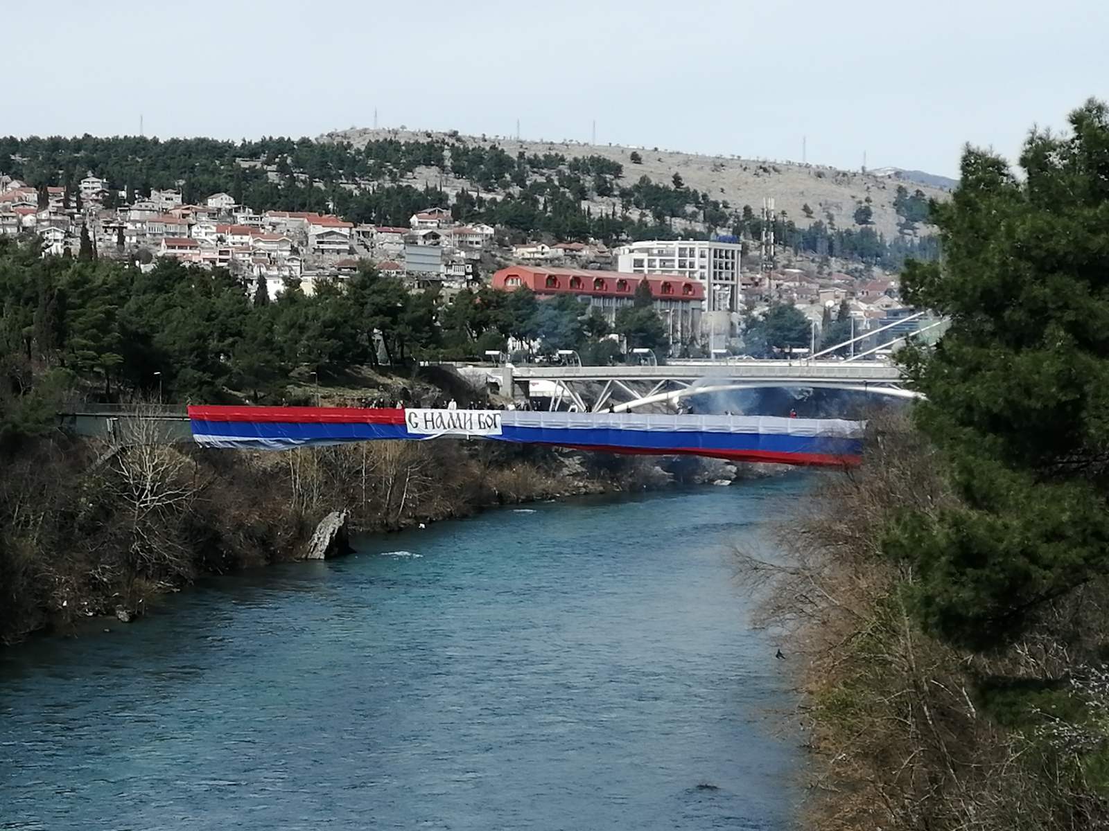 Trobojka i transparent na kom na ruskom jeziku piše "S nama je Bog"